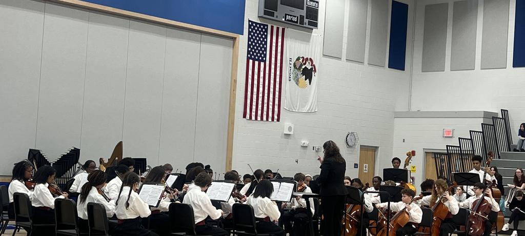 teacher conducts student orchestra