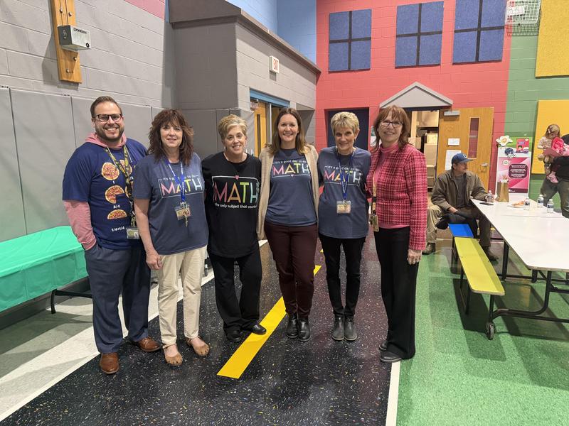 teachers stand in a gym together wearing math shirts