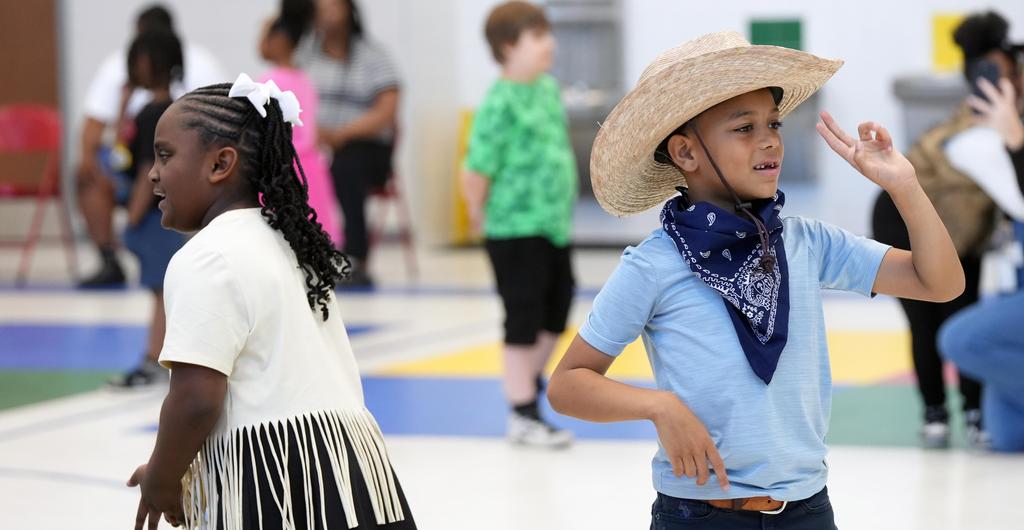 Students square dance in P.E. class.