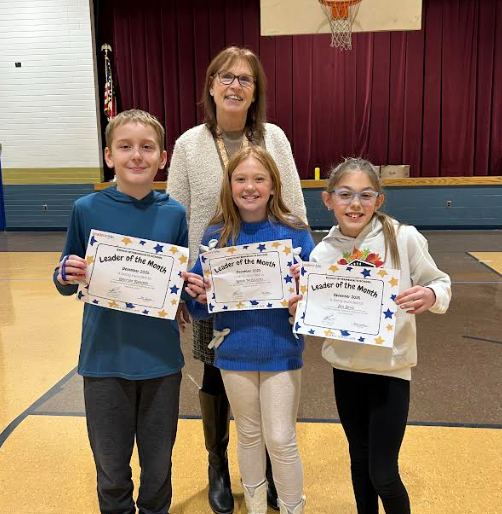 three smiling students holding certificates with principal smiling behind them