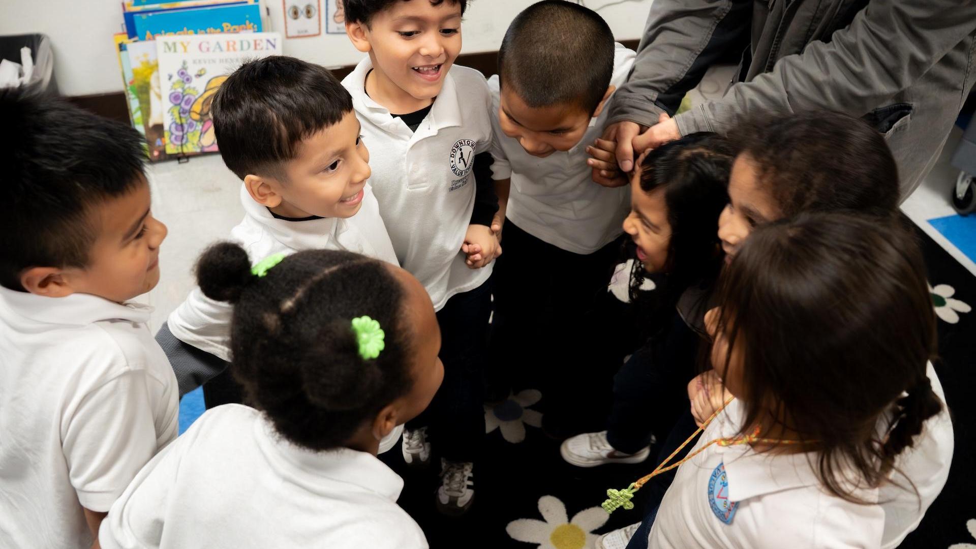 Children in a circle, laughing and engaging with one another.