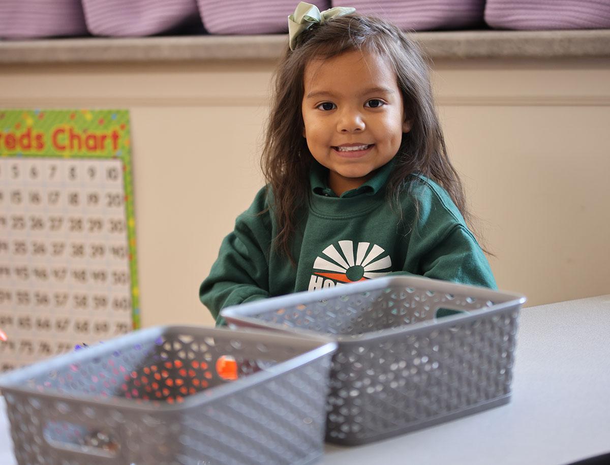 Group of diverse elementary students smiling and posing together in a classroom.
