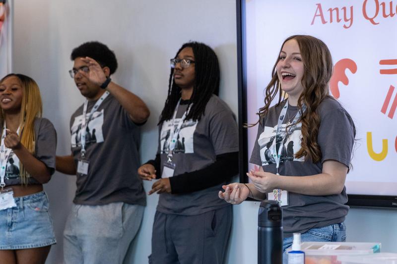 Students laugh while giving presentation