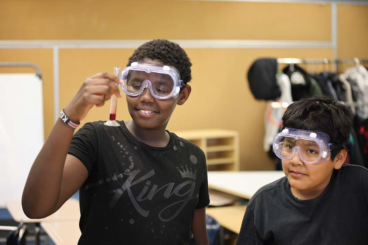 Elementary student smiling and posing together in a classroom.