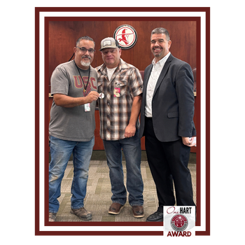 Photo of 3 men, one holding an award