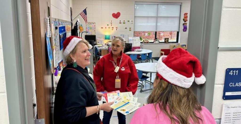 Principals presenting teacher with books for her class.