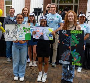 Students posing for picture with their Earth Day poster
