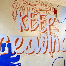 Colorful mural with the text 'KEEP GROWING' and abstract leaf designs.