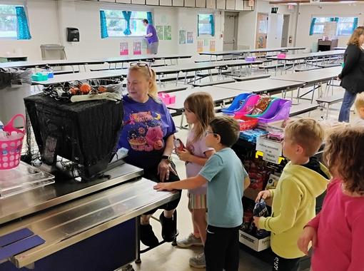 The kitchen manager, serving extras to kindergarten students. 10/2025.