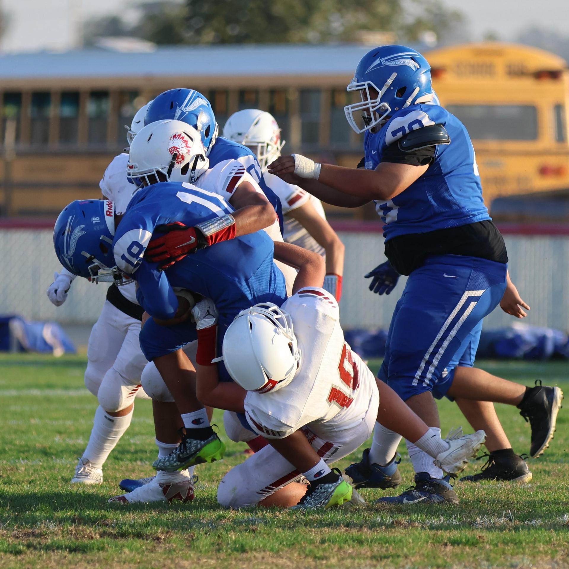 Junior Varsity football players in action against Caruthers