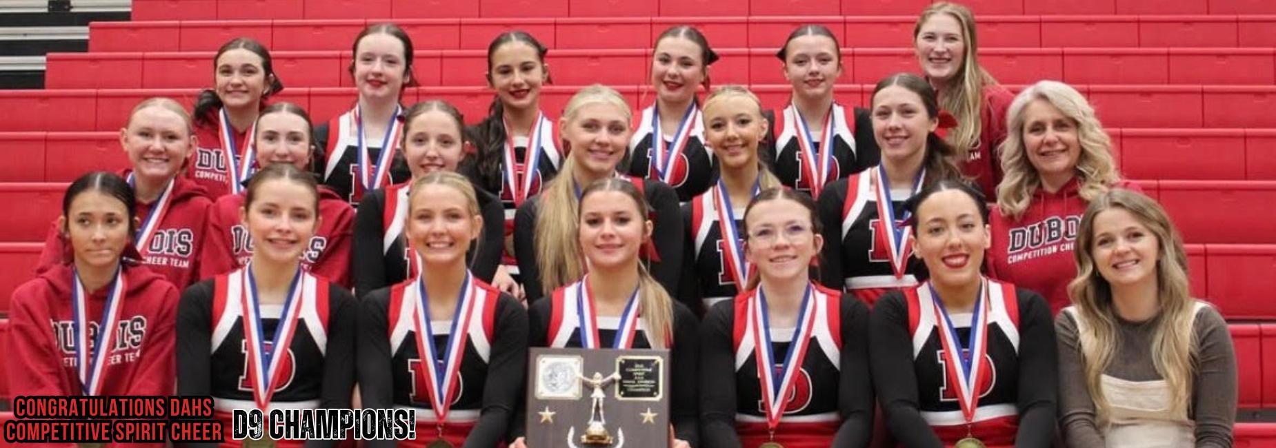 A group of cheerleaders posing with medals and a trophy, celebrating their championship win. DAHS Competitive Spirit Cheer D9 Champions!