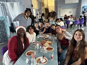 Students sitting in a table eating.