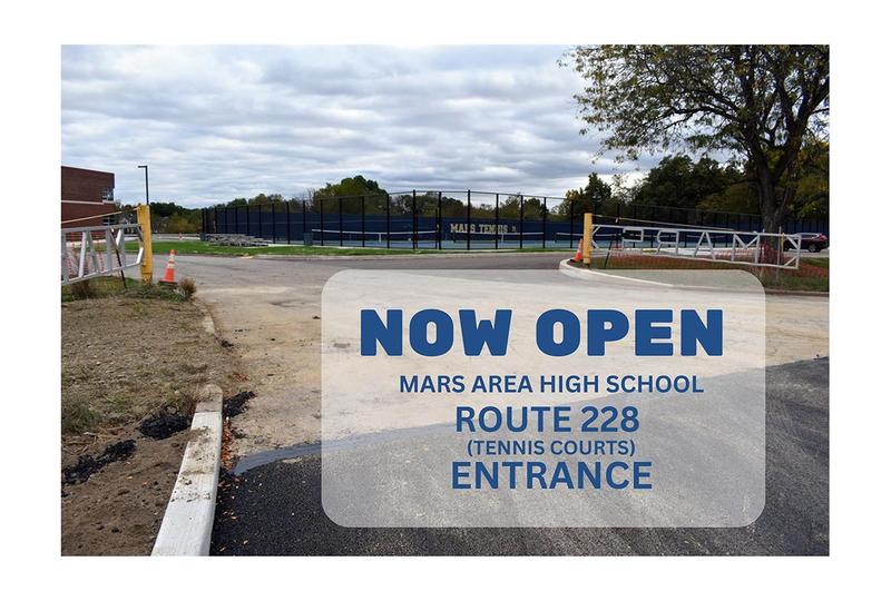 A picture of a parking lot entrance with the words now open