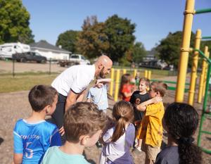 Mr. Sleeman talks with students on the playground.