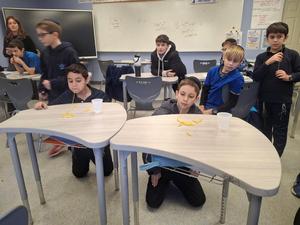 A boy trying to pick up macaroni with a skewer for a minute to win it challenge