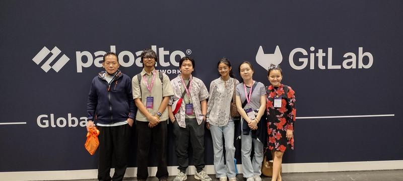 Group of six people standing in front of event banners.