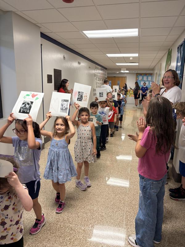 Students holding pictures of their pets