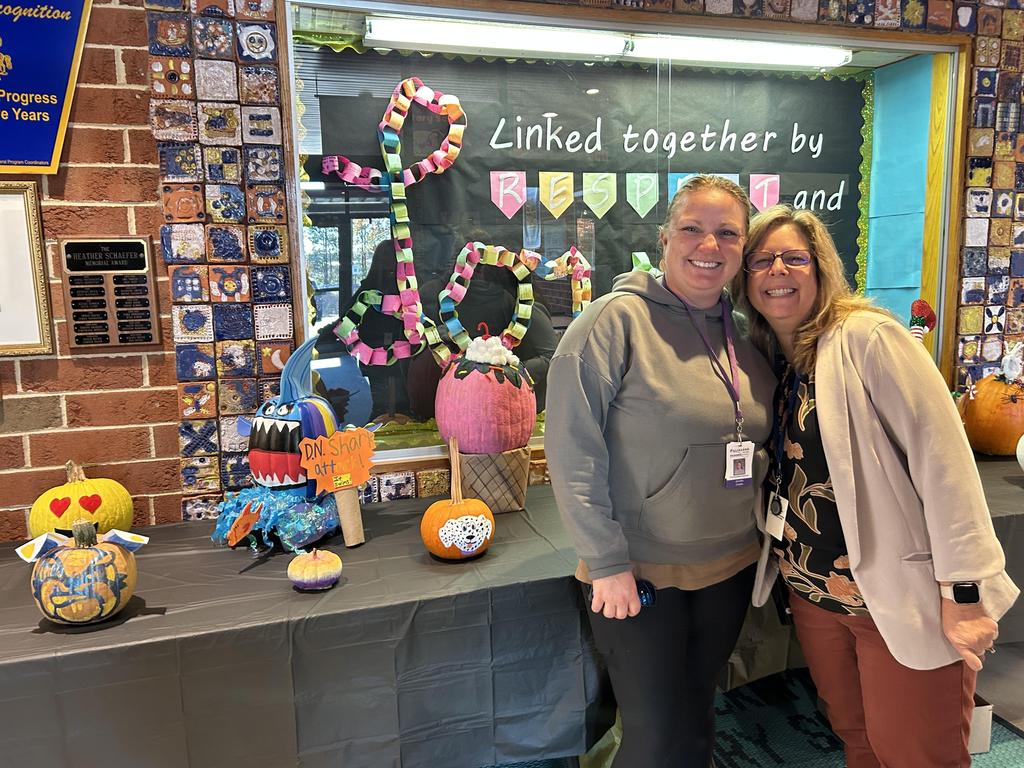 Mrs. Collie and a parent standing in front of the pumpkin contest entries.
