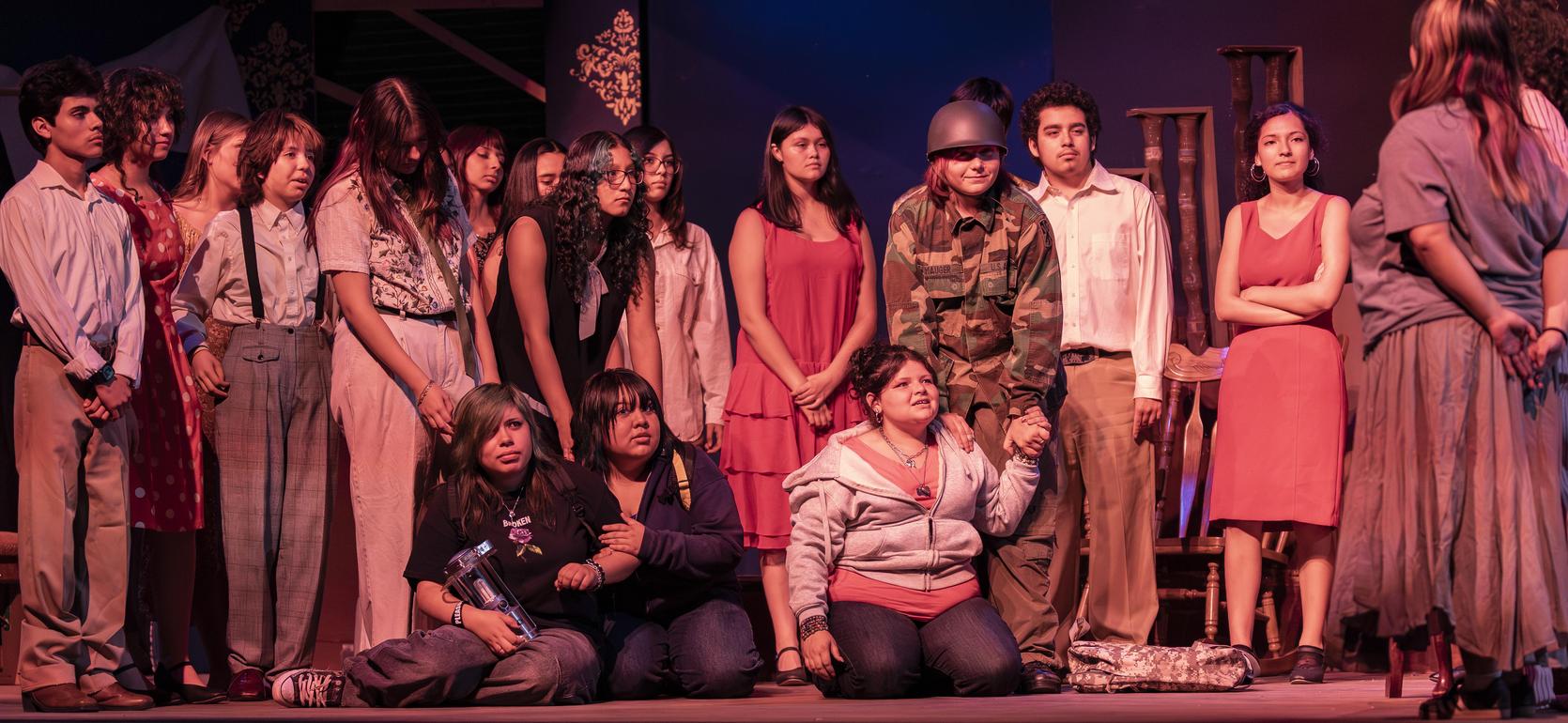 A group of people in a dramatic theatre scene, expressing various emotions.