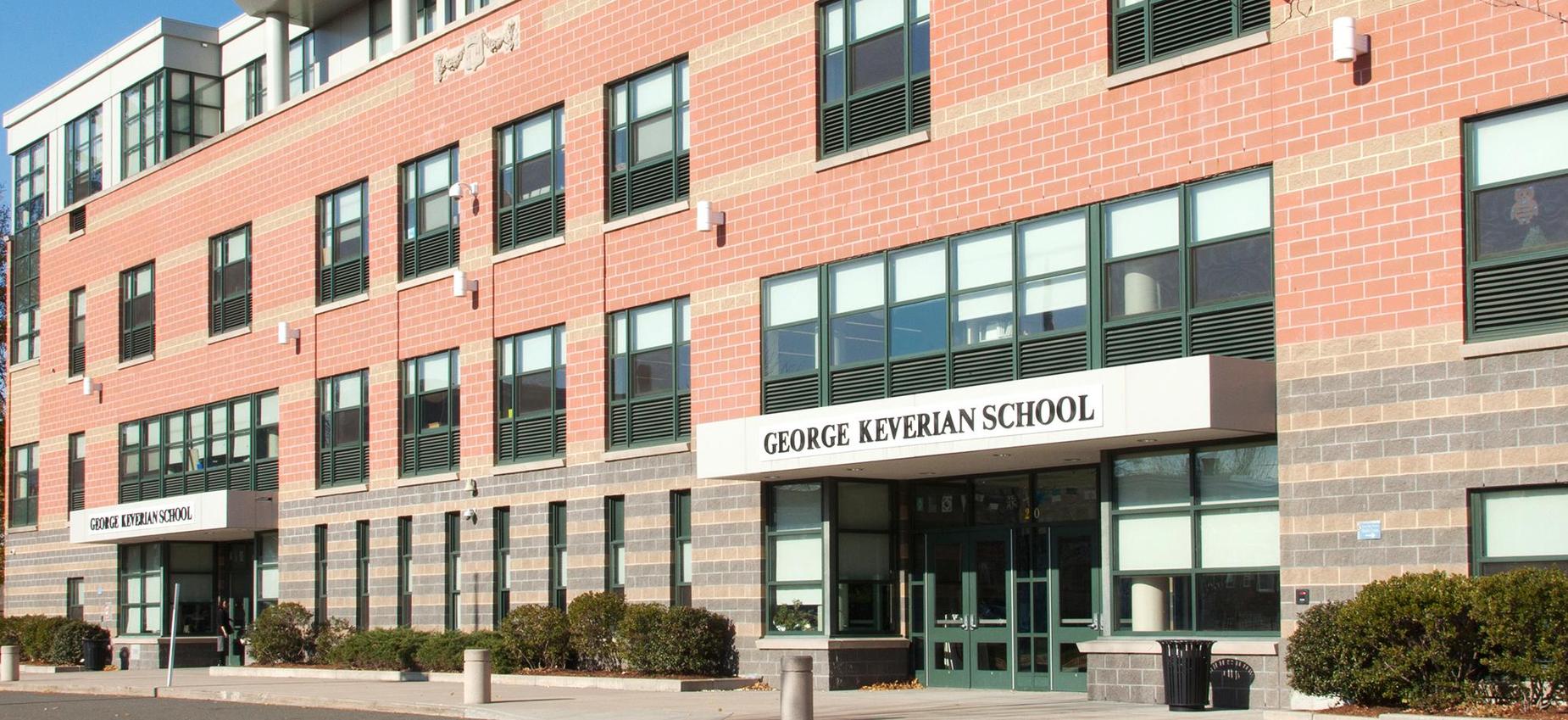Exterior view of George Keverian School with brick walls and large windows.