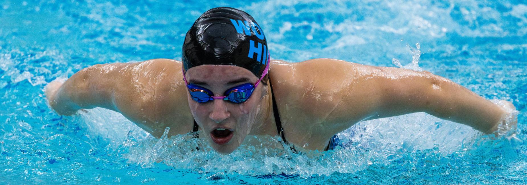 A swimmer comes up for air during a meet