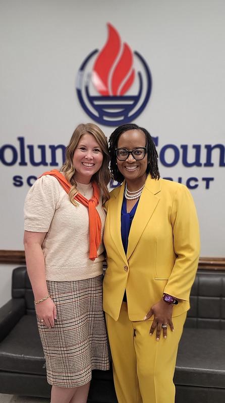 Picture of outgoing Principal, Mrs. Valerie Allen, with incoming Principal, Ms. Barnett. The ladies are standing in front of the CCSD logo.