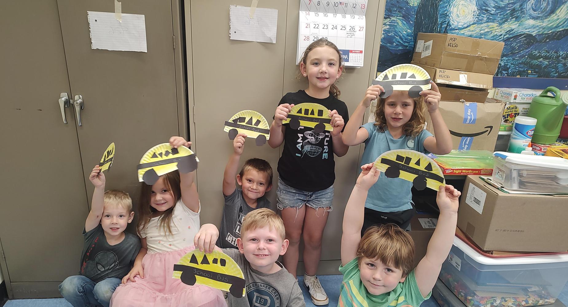Students hold up crafts they created
