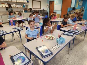 First grade students decorate honey dishes.