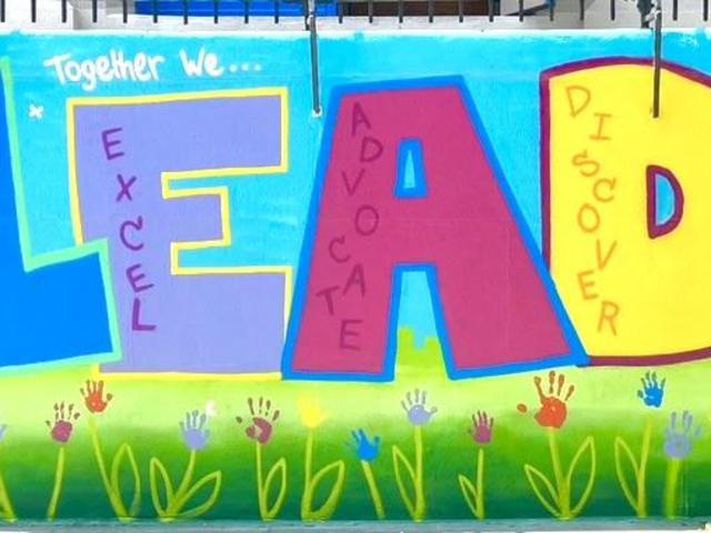 Colorful mural with the word 'LEAD' and phrases emphasizing growth and teamwork.