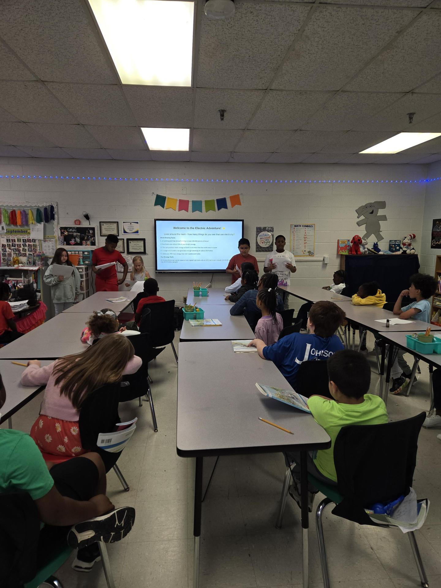 students listening to presentations on electricity
