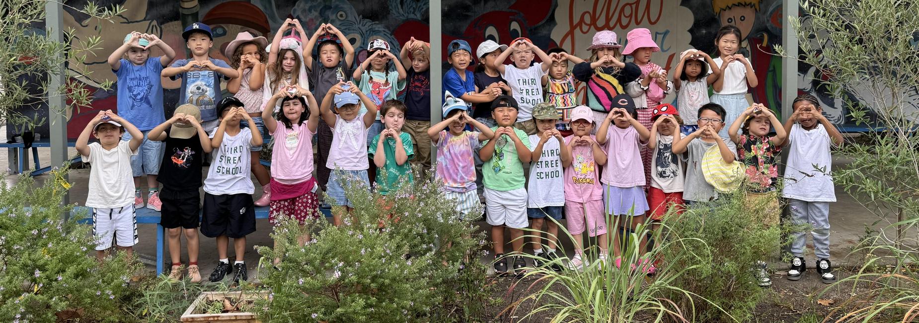 Group of student in garden showing heart hands