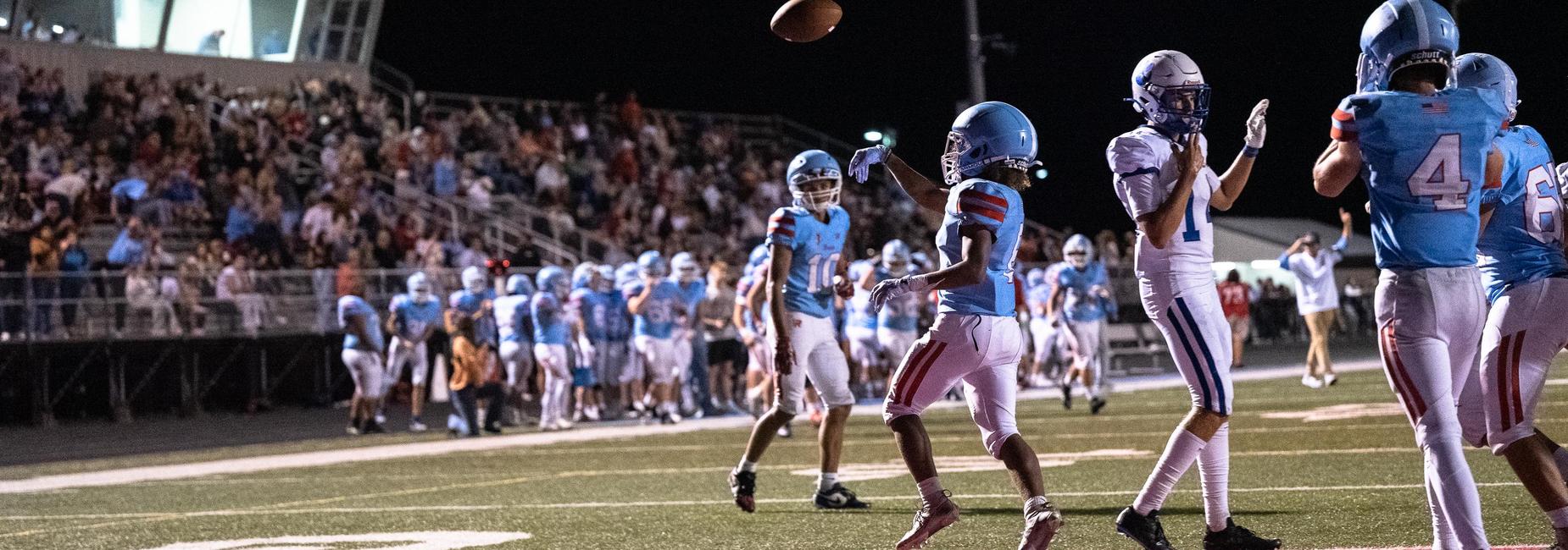 a mac football player goes for the catch