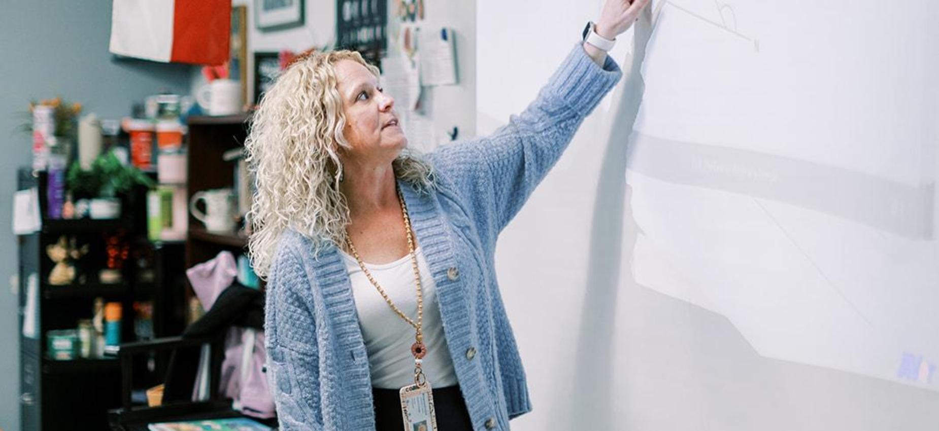 Teacher points to the board during an elementary lesson