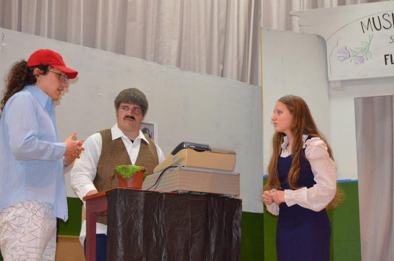 Three students on stage for the theater production.