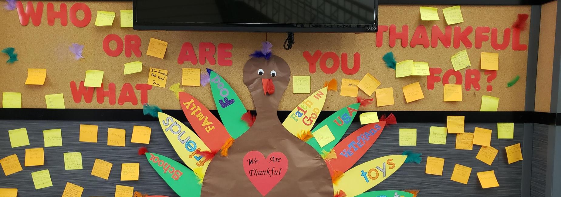 bulletin board with turkey and sticky notes of who/what students are thankful for