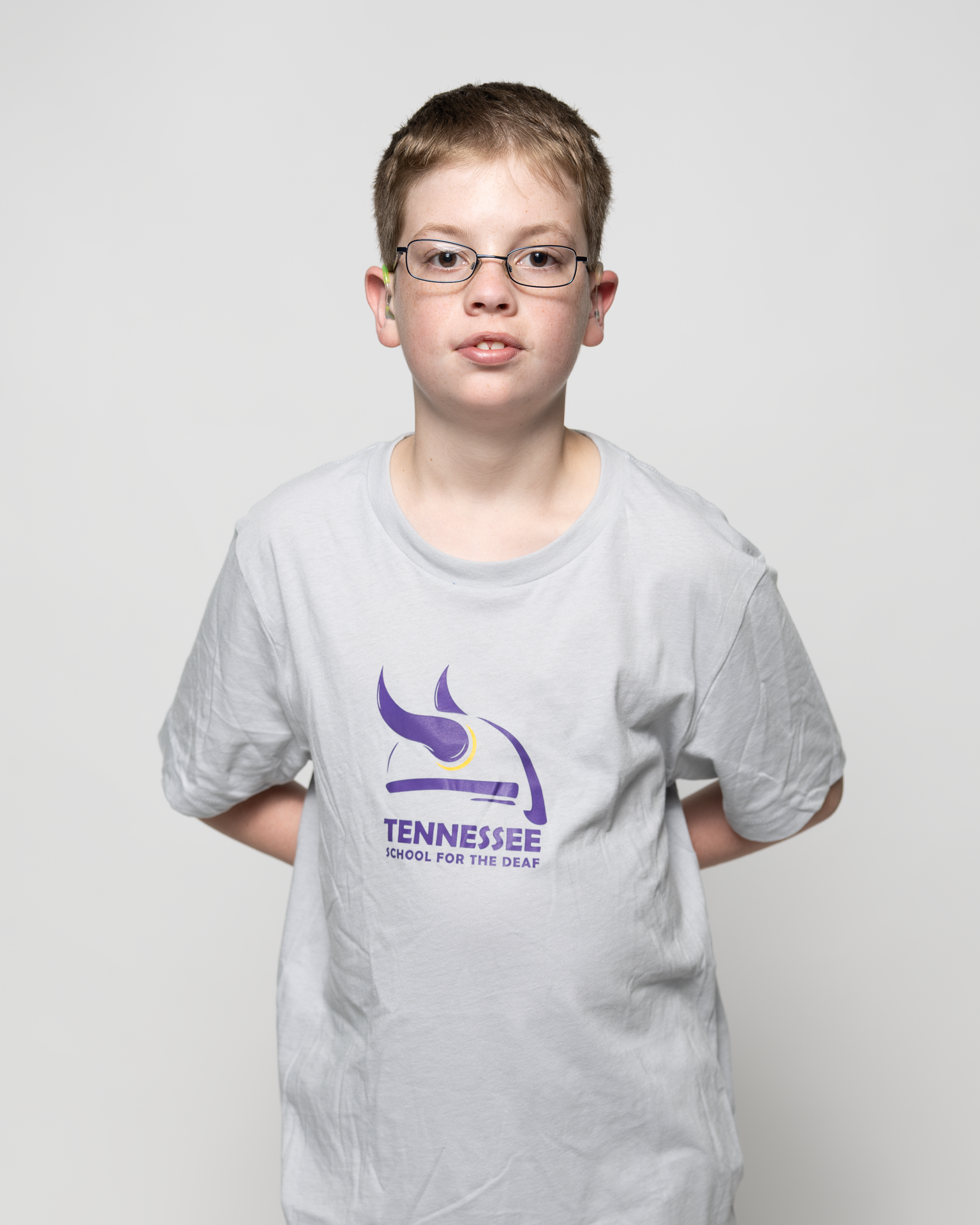 Boy in a gray t-shirt with the Tennessee School for the Deaf logo.
