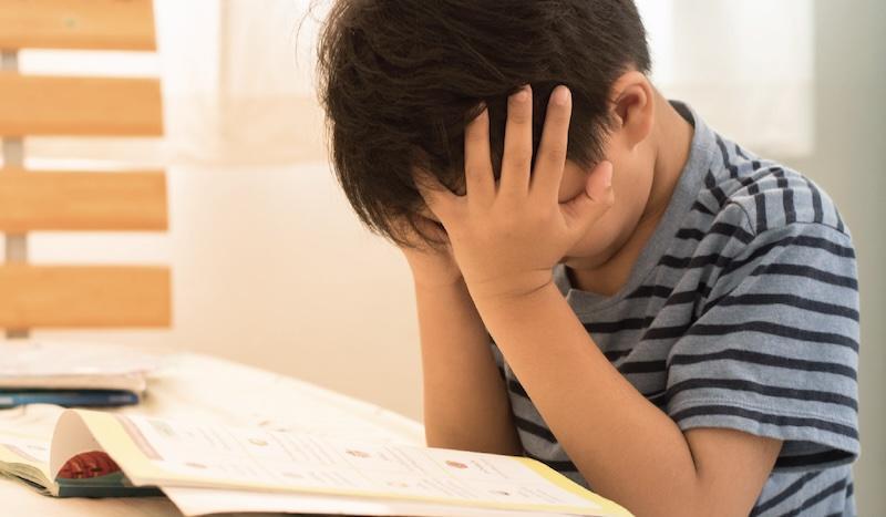 Young student is frustrated trying to read