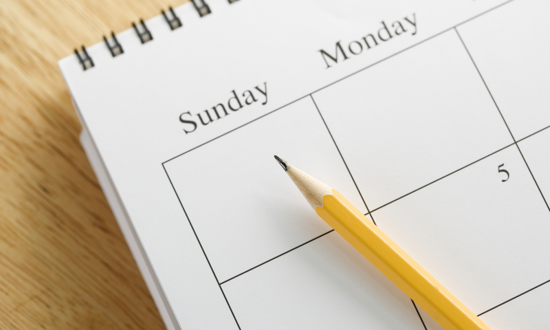 A desk calendar with a pencil laying on top of it