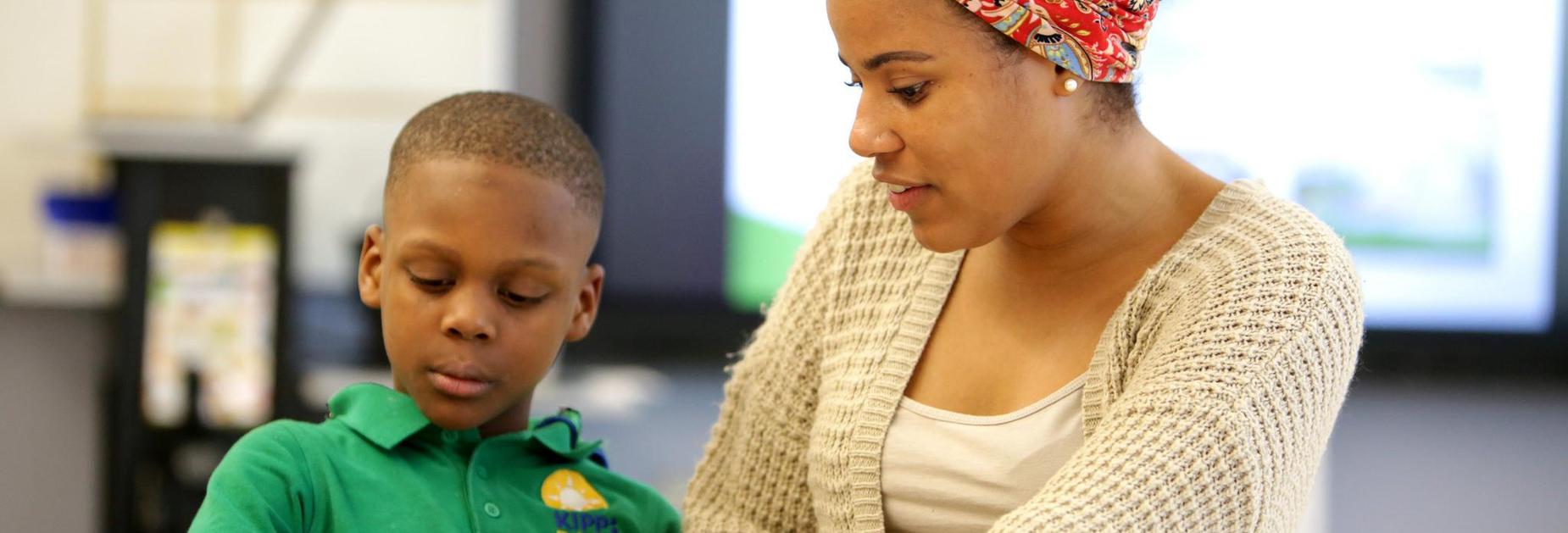 A teacher works with a student on a project