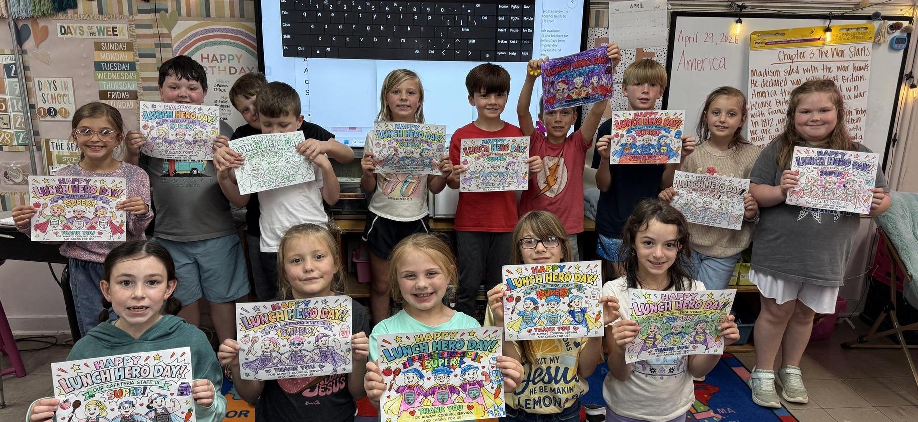 Students happily display colorful artwork celebrating Lunch Hero Day.