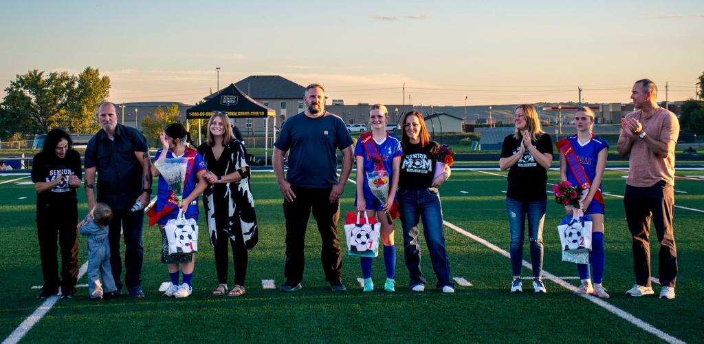DSD Senior Night Soccer. Group of people on a sports field celebrating an event at sunset.