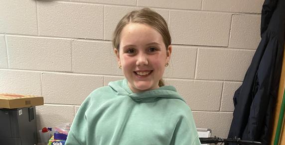 Child wearing a mint green hoodie posing for the camera.