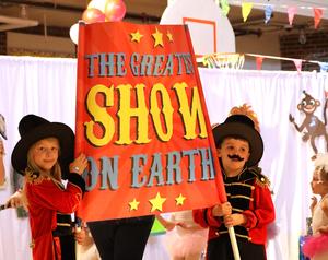 Two students holding "The Greatest Show on Earth" sign.