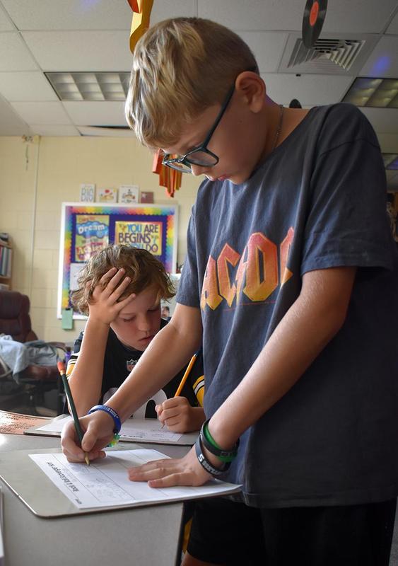 Students completing reading and math activities.