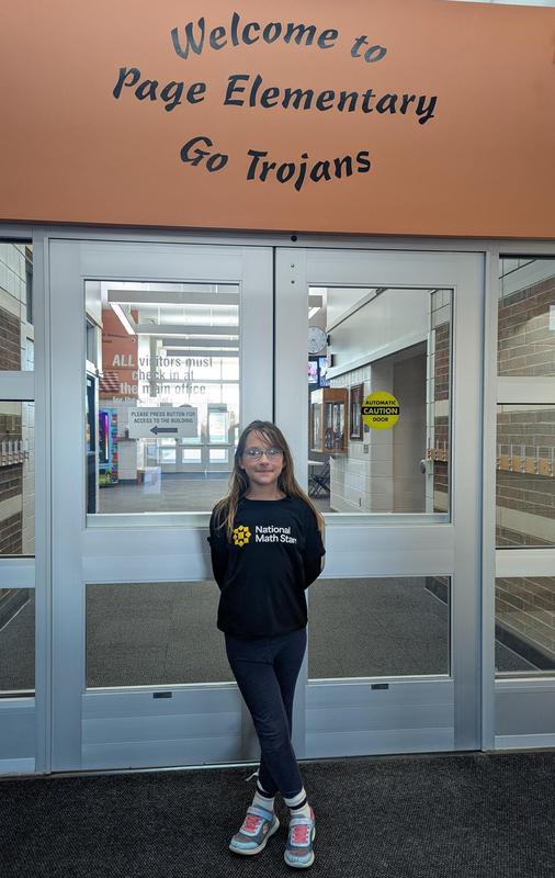 Nine-year-old Lilly Griswold stands under the Welcome to Page Elementary sign.