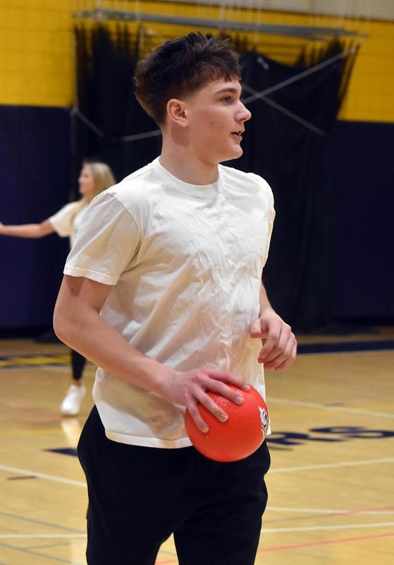 a boy running with a red dodgeball