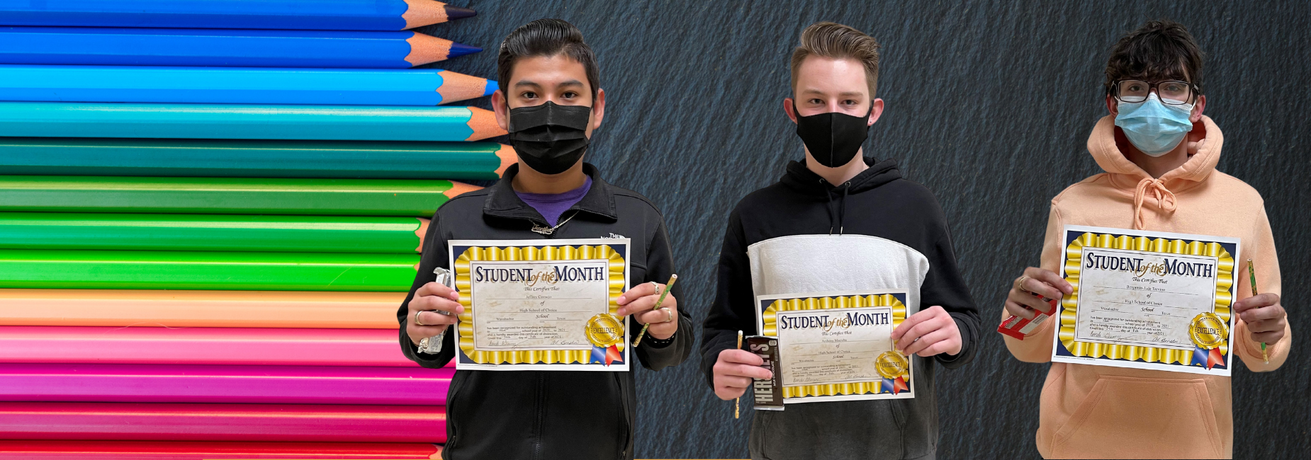 3 boys holding student of the month certificates