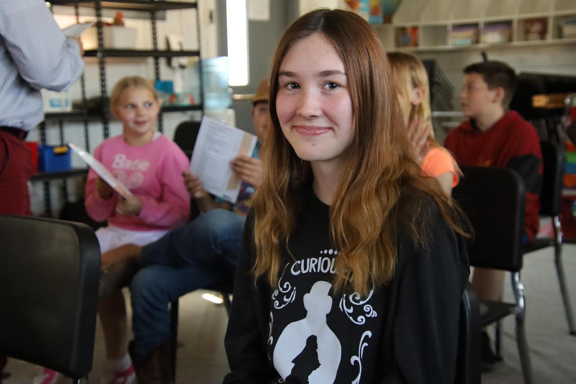middle school girl smiling at camera in the classroom