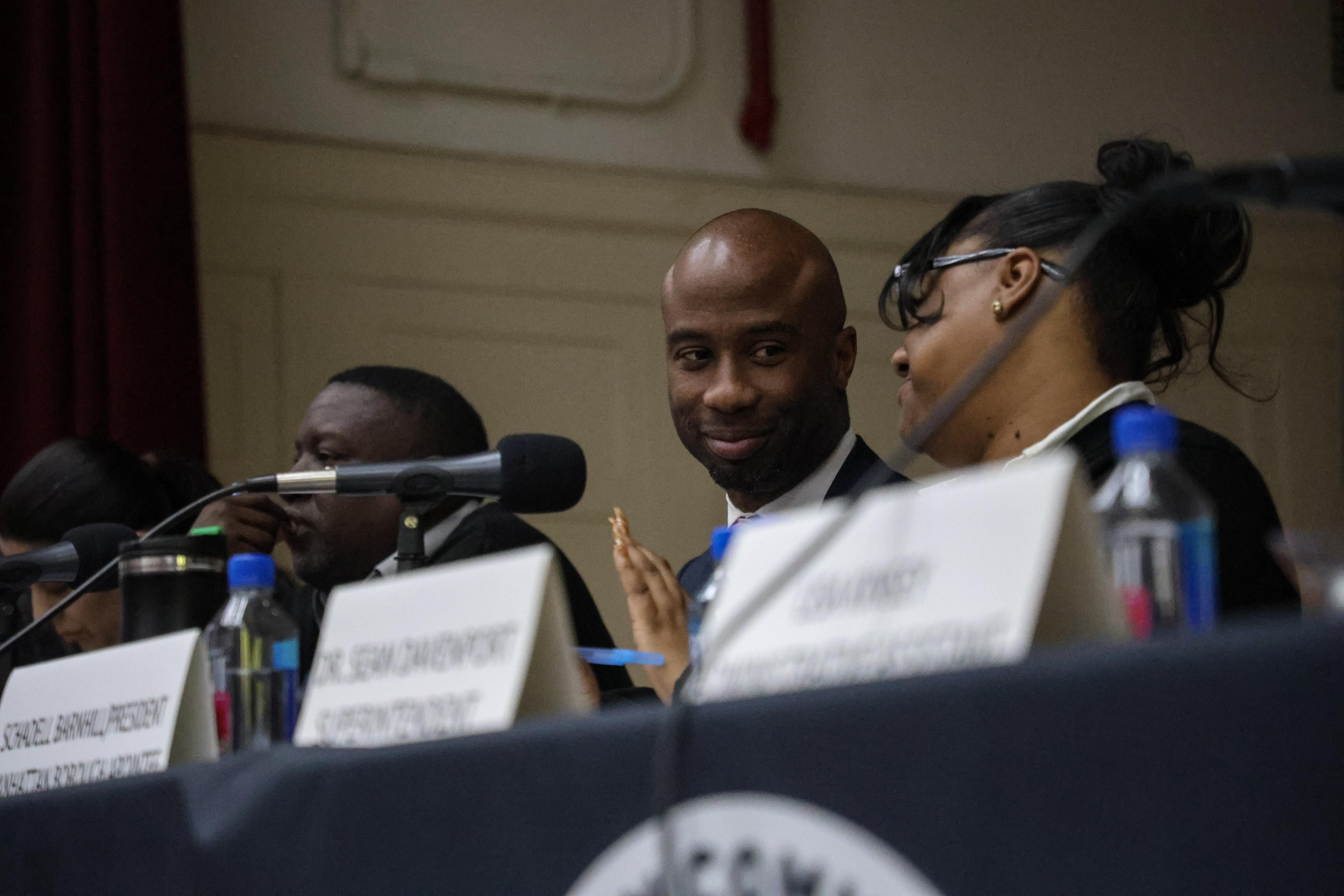 Close-up of a man and woman conversing at a meeting, focused expressions.