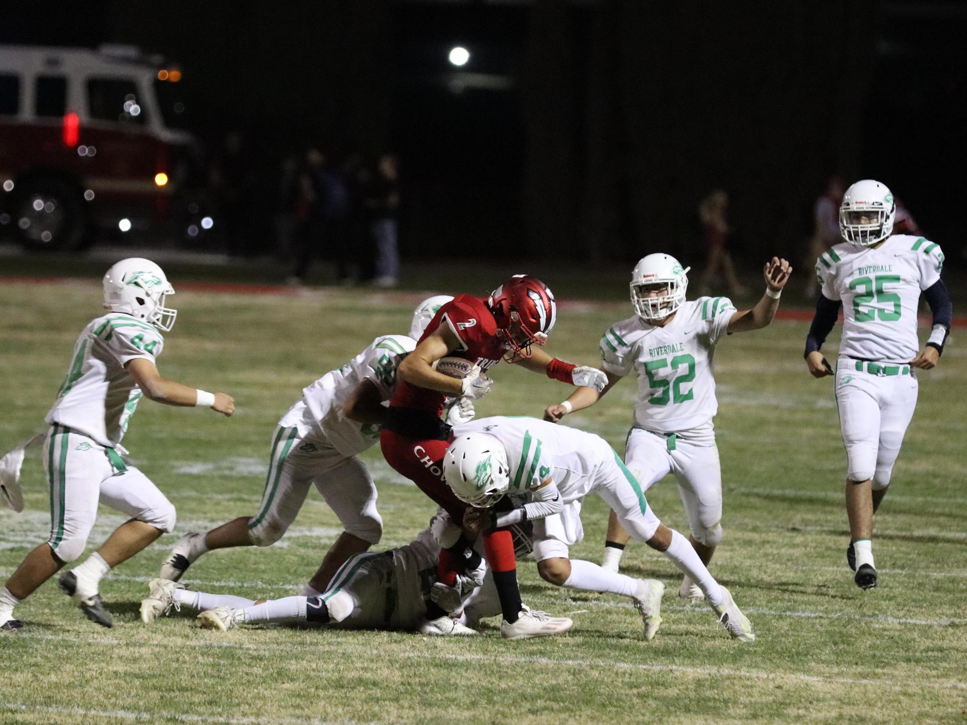 varsity football players in action against Riverdale